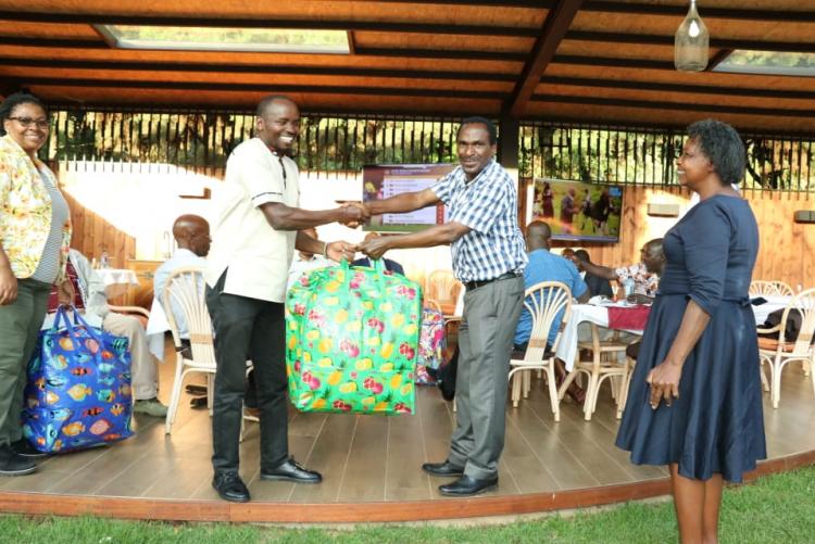 Mr. Rukenya  receiving a gift on behalf of Mr. Muraba from the chairman Prof. Kamucha.