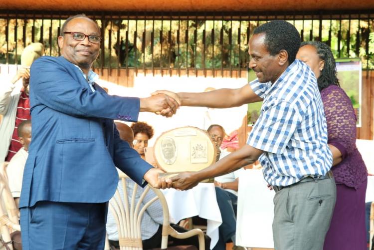 Prof. Mbuthia  receiving a plaque from the chairman Prof. Kamucha. 